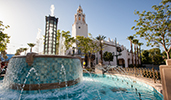A fountain near trees and a building with a marque A fountain near trees and a building with a marque