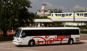 A Disney Transport shuttle bus drives past a monorail track
A Disney Transport shuttle bus drives past a monorail track
