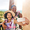 A smiling mother and daughter, wearing leis, take a selfie from their ocean view balcony which overlooks the Waikolohe Pool