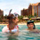 Two young women and a young man with masks and snorkel laugh as they enjoy the ocean at Aulani.